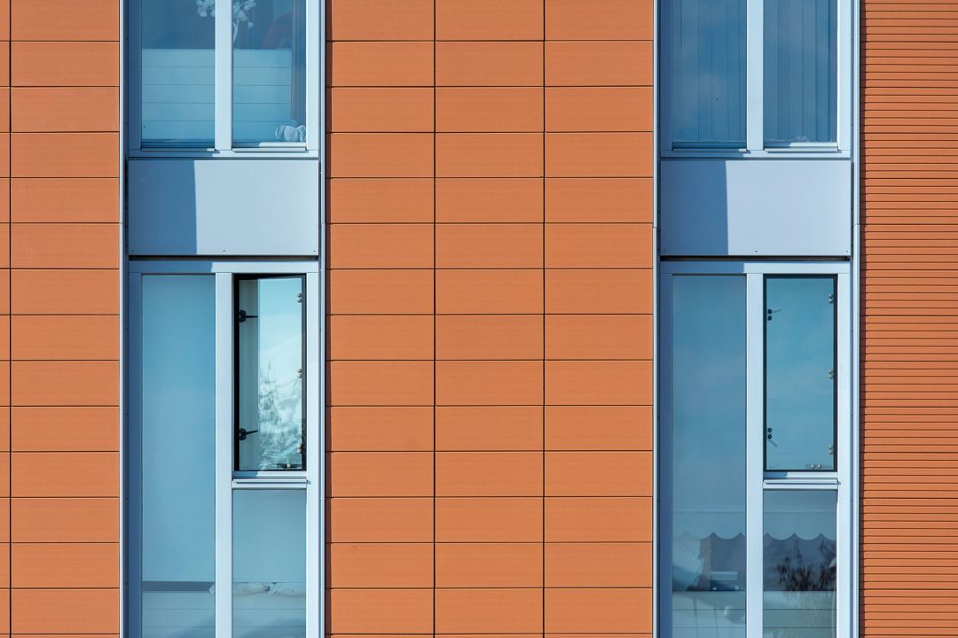 Fassade eines Mehrfamilienhauses mit Plattenverkleidung und Fensterbändern