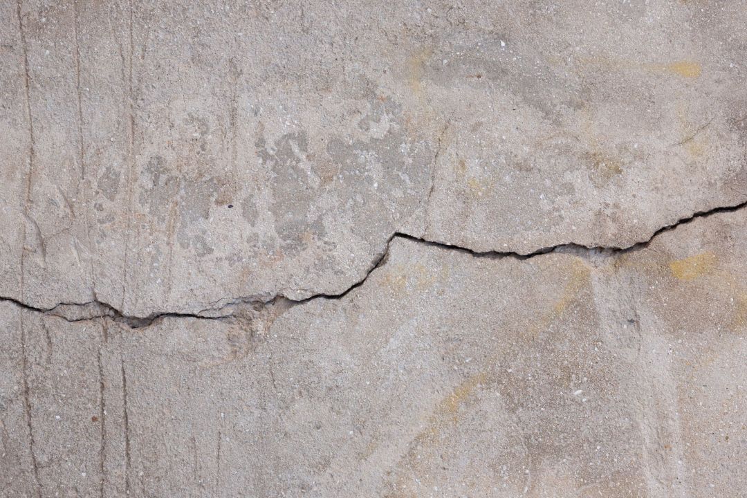 Waagerecht verlaufender Riss in einer verputzten Betonwand aus der Nähe